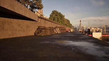 CGI Morning sunlight reflects on tires along a waterfront path in an urban area video