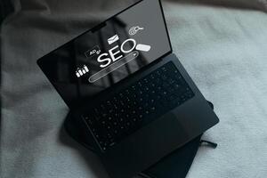 Laptop with SEO icons for analysis on screen. SEO Search Engine optimizing your website to rank in search engines. best promoting ranking traffic on your website. photo