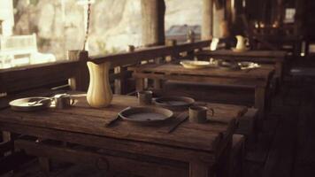 CGI Rustic wooden tables set for a meal in an outdoor dining area at dusk video