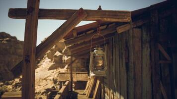 CGI Rustic lantern hanging outside an old wooden cabin in a desert landscape video