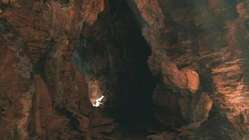 CGI Exploring the hidden depths of a rugged cave illuminated by soft light video