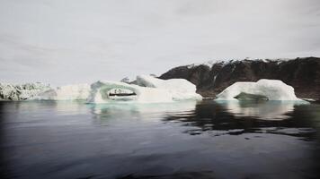 CGI Majestic iceberg formations near a rugged coastline under cloudy skies video