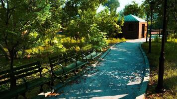 CGI A serene park pathway with benches and a gazebo in the afternoon sunlight video