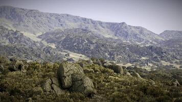 CGI Breathtaking view of rugged mountains with large boulders under clear sky video