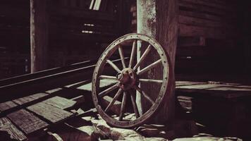 CGI Old wooden wagon wheel resting against a post in a rustic barn setting video
