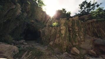 CGI Sunlight streaming through moss covered rocks at a cave entrance in Indonesia video