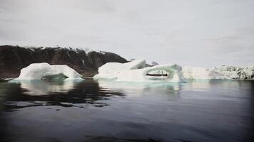 CGI Majestic iceberg formations reflecting in calm coastal waters at dawn video