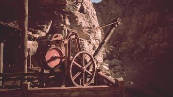 CGI Ancient machinery rests near rocky cliffs in a historic mining location video