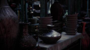 CGI Antique pottery and plates displayed in a dimly lit market setting video