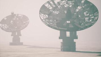 CGI Large satellite dishes stand in foggy atmosphere during early morning hours video