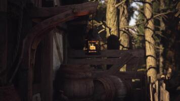 CGI Lantern hangs in the forest near old barrels and rustic wooden structure video