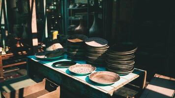 CGI Stacked metallic plates displayed on a wooden table in a market setting video