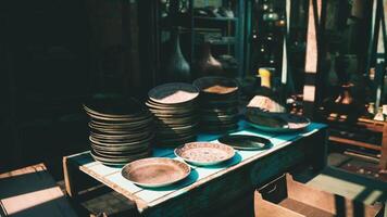 CGI Stacked plates and bowls displayed on a wooden table in a market video