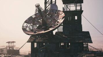 CGI Old satellite dish on a rusty tower in a desolate landscape at dusk video