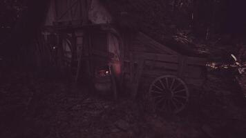 CGI Old wooden cart near a rustic cabin in the dark woods at night video