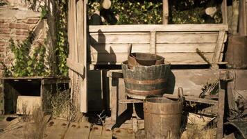 CGI Rustic outdoor setting featuring wooden buckets and a weathered wall video