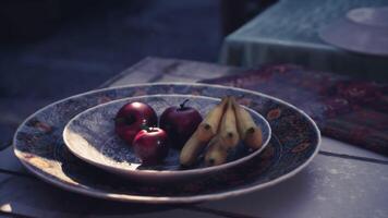 CGI Colorful fruits on decorative plates in a cozy outdoor setting during evening video