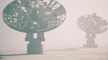 CGI Large satellite dishes in foggy landscape at sunrise near remote location video
