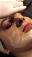 A woman getting a facial treatment in a salon video
