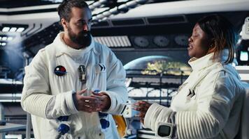 Astronauts discussing last details stepping out for scheduled operations outside starship exploring deep space. Cosmonauts chatting, preparing for mission launch after landing on planet, camera B video