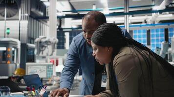 African american specialists supervisors examining production metrics on papers, supporting industrial innovation and alternative energy manufacturing process. Solar power. Camera B. video