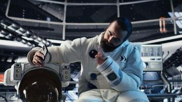 Astronaut records selfie with smartphone, making hand gestures, speaking to subscribers during Mars mission. Cosmonaut recording cosmic exploration content for followers, camera B video