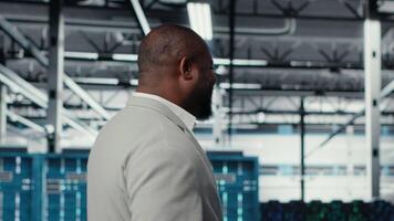 Happy businessman walking in data center, assessing rackmounts capacity before investing. Jolly management executive overseeing server farm built for business storage gear, camera B video