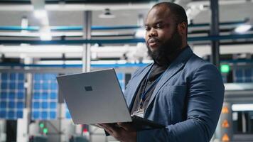 African american director in a solar panels facility monitoring performance and efficiency metrics, combining leadership with real time quality control and strategic business development. Camera A. video
