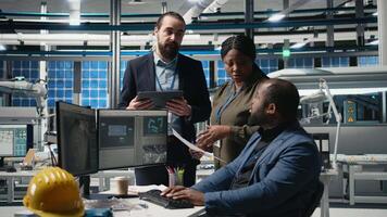 Multiethnic master engineers doing teamwork on high tech production line for solar panels manufacturing activity, combining technical insight and collaboration for green energy. Camera B. video