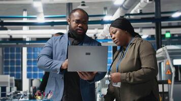 African American industrial coworkers doing teamwork on production line for solar panels, combining technical insight and teamwork to drive forward clean energy infrastructure. Camera A. video