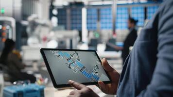 Solar power technician reviewing data on tablet in photovoltaics factory, inspecting manufacturing plant performance and production line for solar innovation. Alternative energy. Camera B. video
