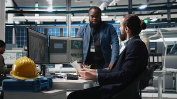 Portrait of diverse engineers managing solar panel systems as part of a collaborative inspection, ensuring sustainable technology and industrial activity for photovoltaics production. Camera B. video