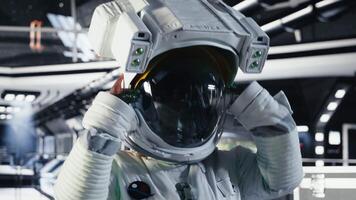 Portrait of happy astronaut holding helmet before stepping out for scheduled operations outside orbital station. Smiling cosmonaut in spacecraft approaching distant planetary surface, camera B video