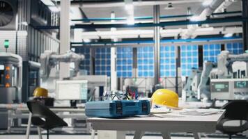 High tech manufacturing environment showing robotics in action, photovoltaic system monitoring and essential safety equipment on a desk. Modern renewable energy production line. video