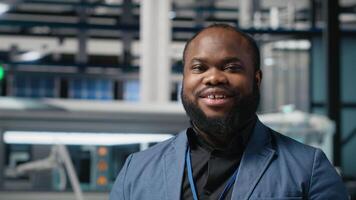 Black master engineer in suit verifies solar panel production in factory, representing technical precision and corporate strategy in the future of green energy. Assembly line. Camera A. video