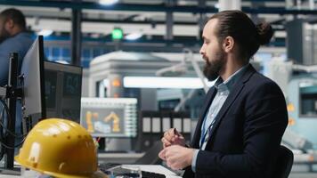 Master engineer studying production line metrics on pc and files, handling manufacturing process of photovoltaics creation to ensure clean energy. Industrial expert in modern factory. Camera A. video