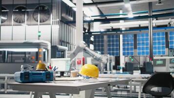 High tech solar cell manufacturing process with empty desk and safety gear, modern workspace used in creating solar panels to guarantee green energy. Industrial machinery assembly line. video