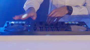 Live DJ performance of emotional energetic man with mixer controller. Composing new mix, dancing, performing on concert musician stage with lights. Party, music festival show concert. Slow motion video