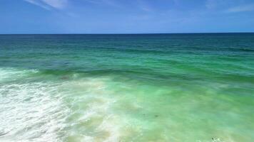 A breathtaking seascape that showcases stunning turquoise waters and gentle waves beneath a clear blue sky photo
