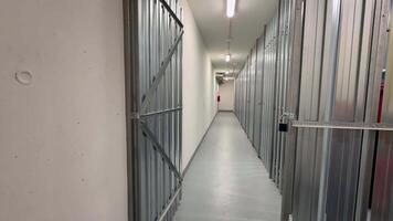 A long corridor elegantly lined with multiple secured storage units, effectively showcasing a modern storage facility photo