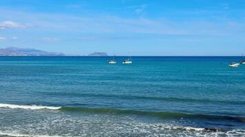 Experience a serene seaside view with colorful boats floating on clear waters under a bright blue sky photo