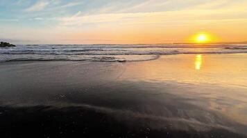 A breathtaking view of a stunning golden sunset beautifully reflecting on the tranquil ocean waves at the beach photo