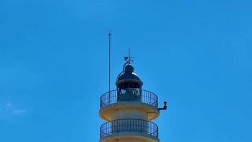A stunning lighthouse stands tall and proud against a vibrant blue sky, symbolizing guidance and safety for all photo