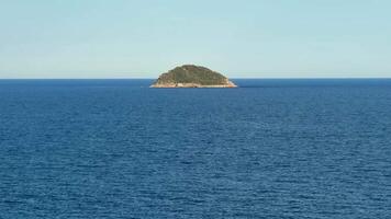 A serene and tranquil island is elegantly surrounded by the deep blue sea under a bright and clear sky photo
