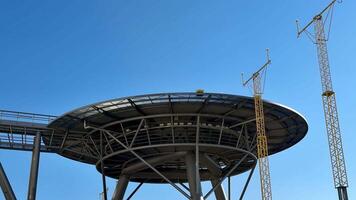 A modern architectural design featuring a circular shape set against a stunning backdrop of a clear blue sky photo