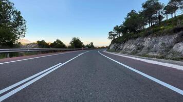 A breathtaking and picturesque view of a winding road that is beautifully surrounded by nature at sunset photo