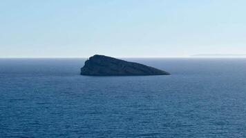 A tranquil view of the vast ocean, with a solitary rock on the horizon, illustrating natures beauty and serenity photo