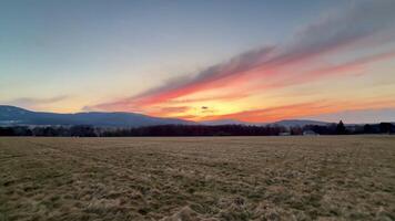 A breathtaking and stunning sunset casting vibrant and radiant colors over vast open fields and distant mountains photo