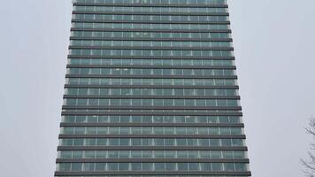 This is a sleek, modern building that showcases a striking glass facade along with unique design elements photo