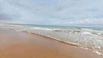 A tranquil and picturesque beach scene showcasing gentle waves gracefully lapping against the soft, golden sand photo